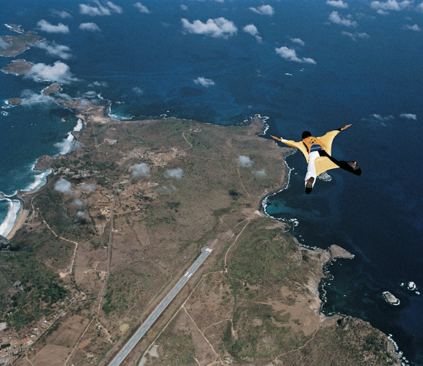 Luís Roberto Formiga voando de wingsuit sobre Fernando de Noronha